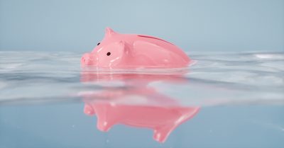 Petit cochon rose flottant dans un dégât d'eau.